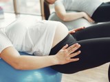 Zwangere vrouw krijgt fysiotherapie onder begeleiding.