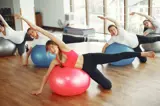 Mensen doen fysiotherapie-oefeningen met een skippybal.